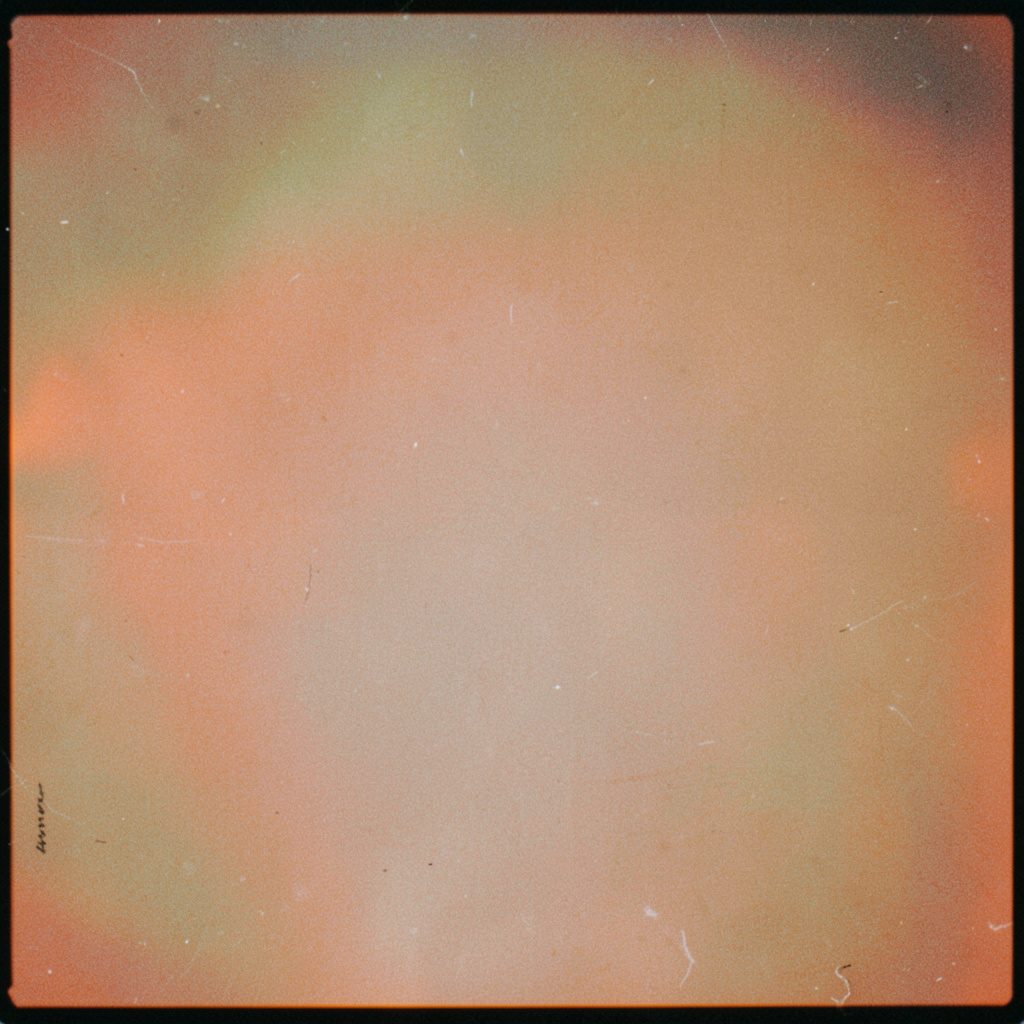 A grainy analog photograph of a softly lit conversation space with warm amber and deep navy tones, two chairs angled toward each other across a low table, the atmosphere intimate and contemplative.